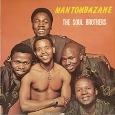 Five men on a vinyl album cover, one shirtless and the other in brown traditional African print shirts.