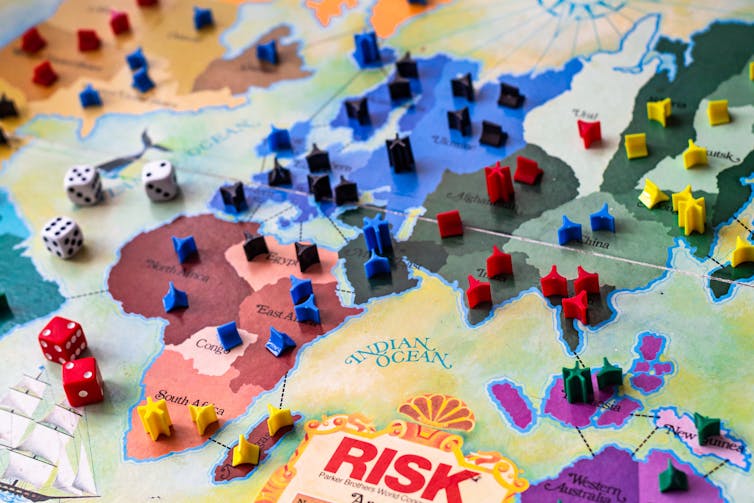 The board game risk with game pieces on a map of the world.