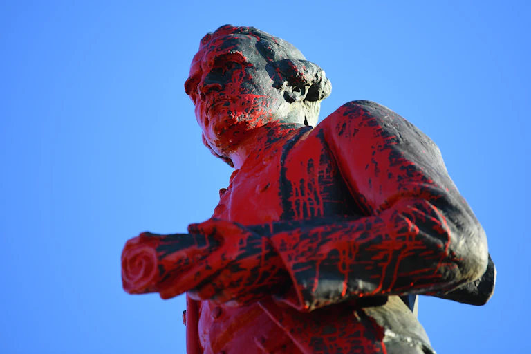 A Captain Cook statue splashed with red paint.