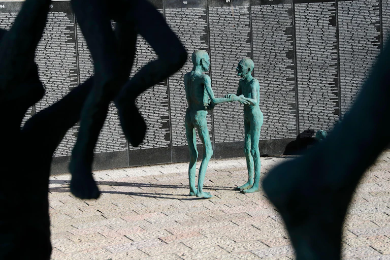 statue of two people holding arms.