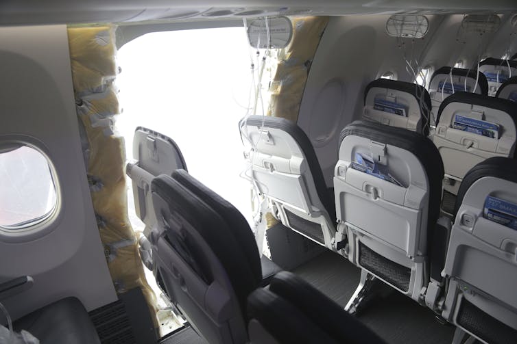 Los asientos de las aerolíneas se encuentran al lado de una abertura en el costado de un avión.