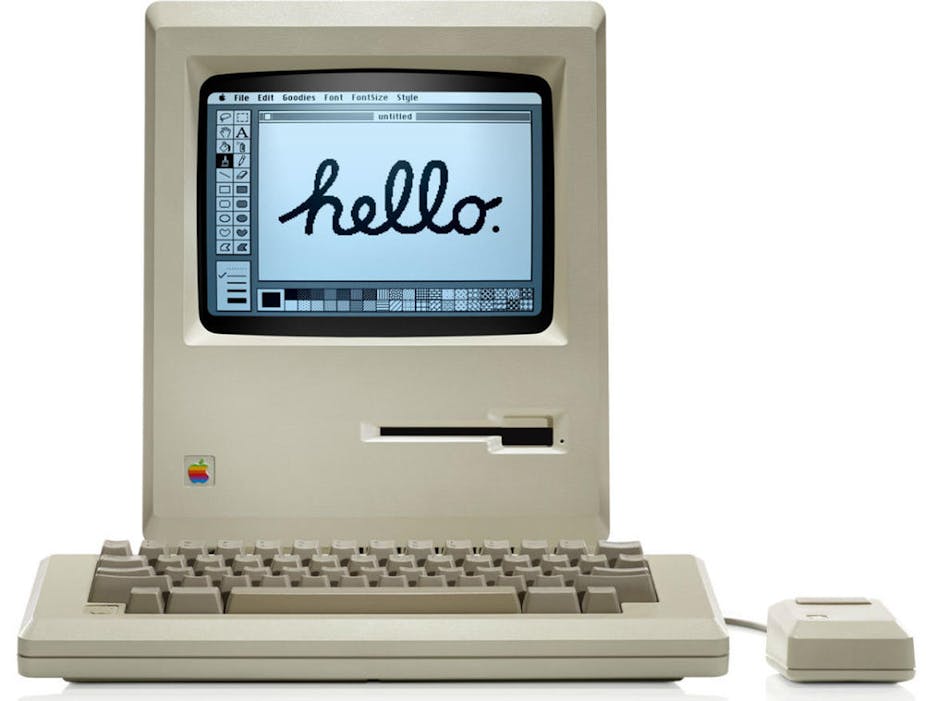 a box-shaped computer with a small black and white screen displaying handwritten text