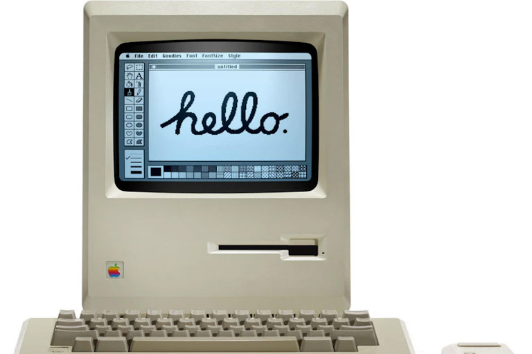 a box-shaped computer with a small black and white screen displaying handwritten text