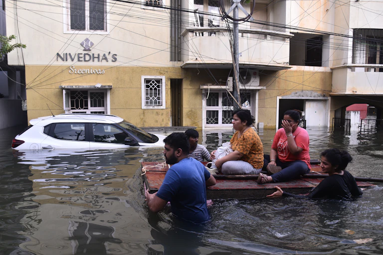 two people push others on makeshift raft through floodwaters in India