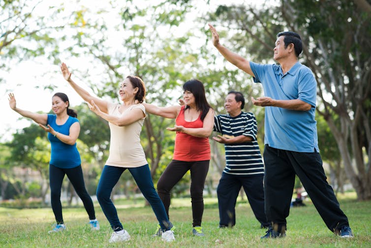 People doing Tai Chi in a park