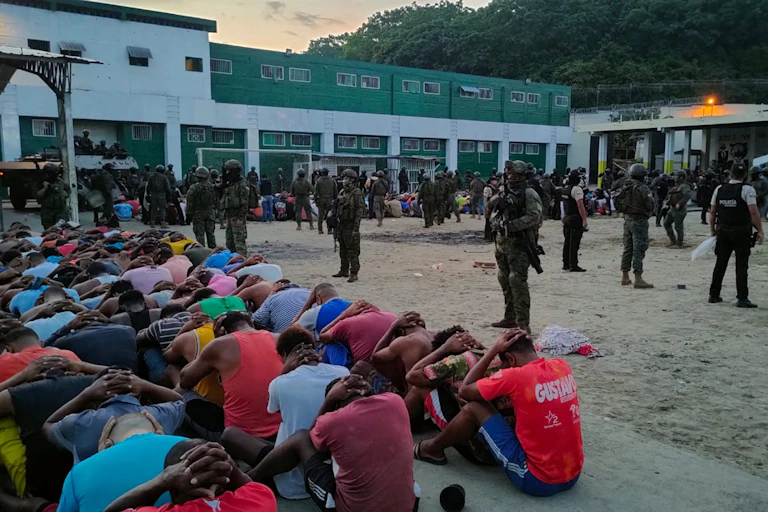 Soldiers stand guard over a greap of prisoners at a jail in Ecuador, January 2024.