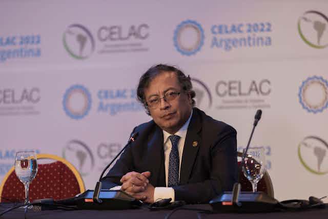 Colombia's president Gustavo Petro sitting at a microphone.