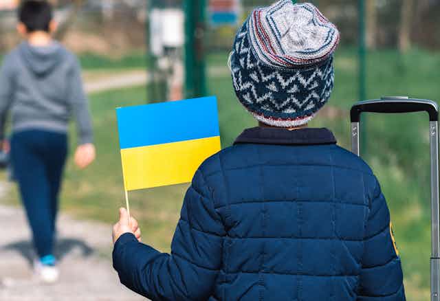 A child with a hat and a Ukrainian flag.