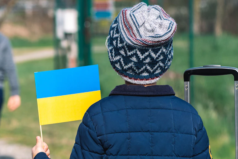 A child with a hat and a Ukrainian flag.