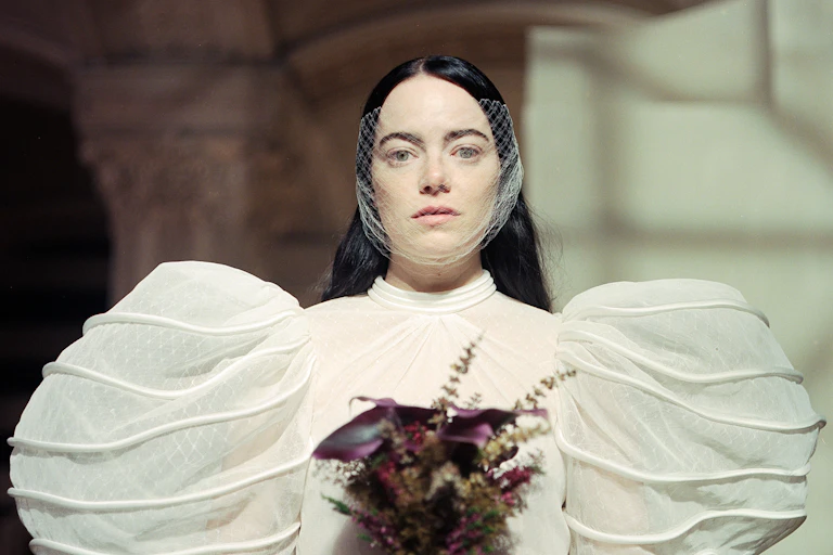 Emma Stone interpreta a Bella Baxter con un vestido blanco con grandes mangas abullonadas