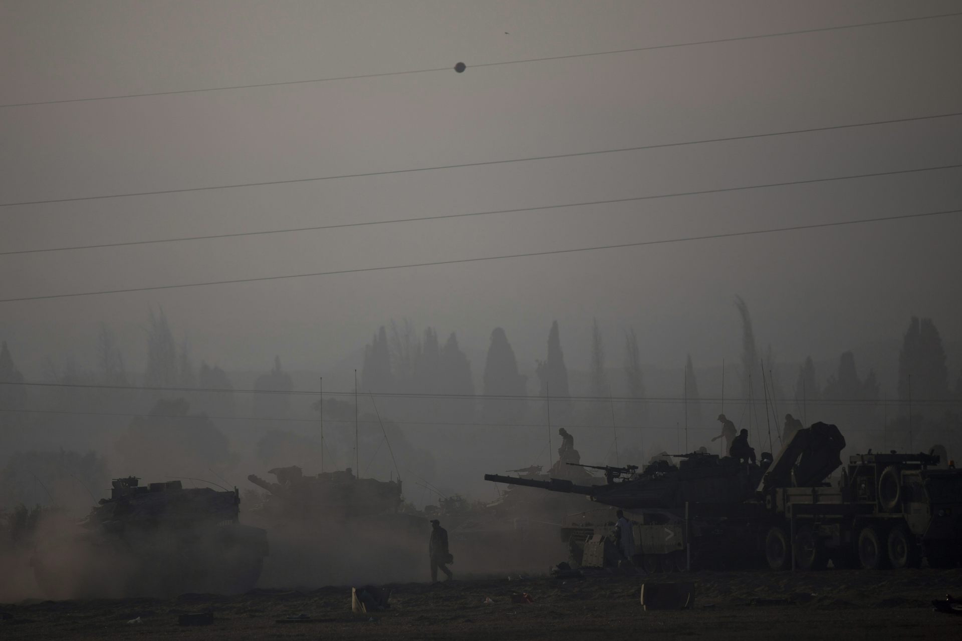 Men work on tanks in the fog.