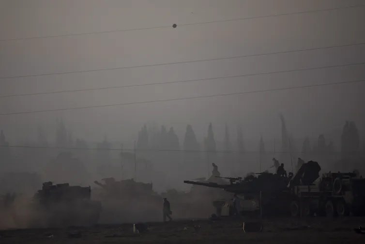 Men work on tanks in the fog.