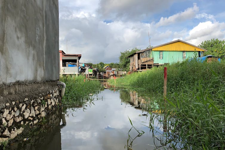 Looking along a water channel towards an informal settlement in Makassar, Indonesia