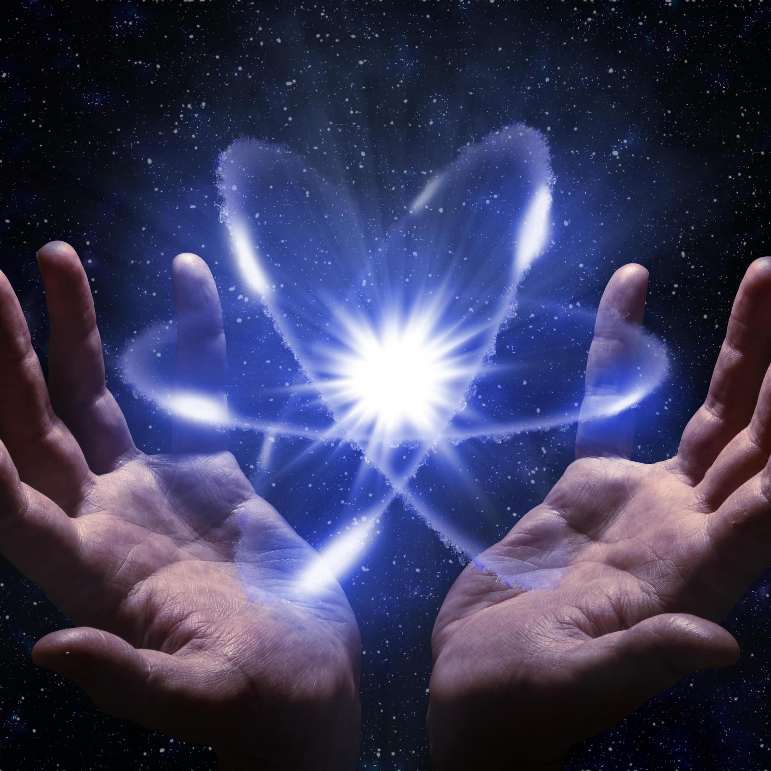 mains humaines tenant une représentation planétaire d'atome