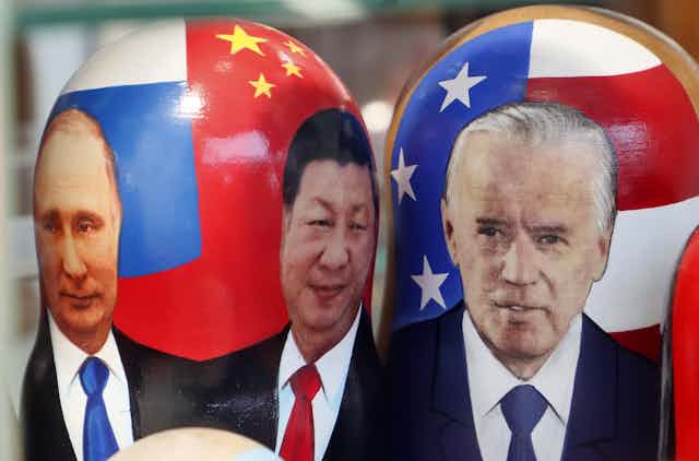 Russian nesting dolls, illustrated with the images of Russian President Vladimir Putin, Chinese President Xi Jinping and US President Joe Biden