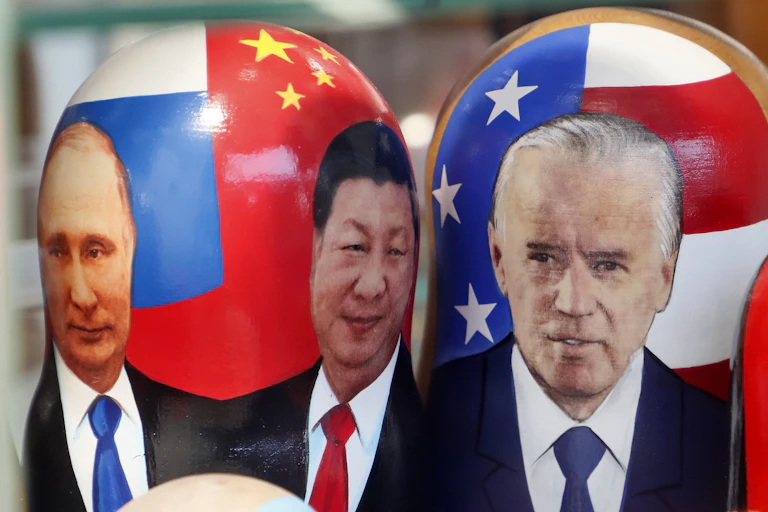 Russian nesting dolls, illustrated with the images of Russian President Vladimir Putin, Chinese President Xi Jinping and US President Joe Biden