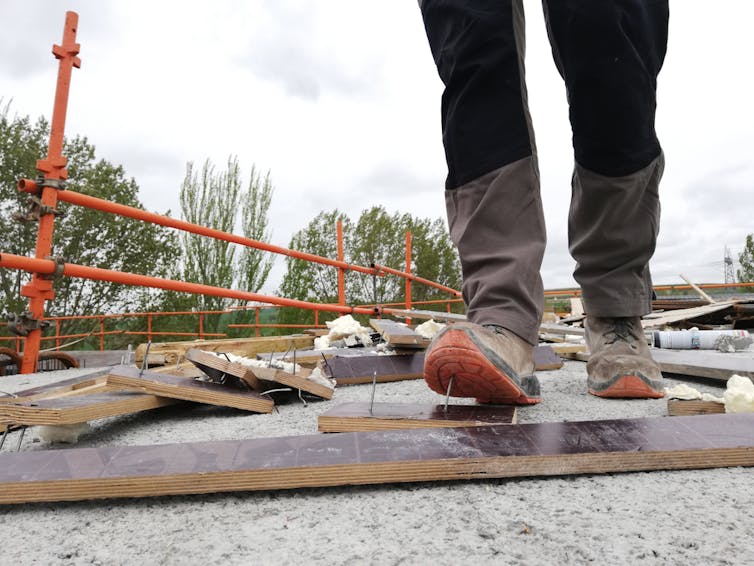 A builder about to step on a nail