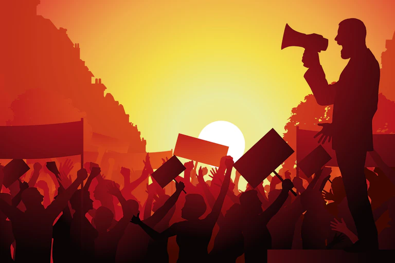 An illustration of a man shouting into a megaphone in front of a crowd of people waving their arms and holding up placards.