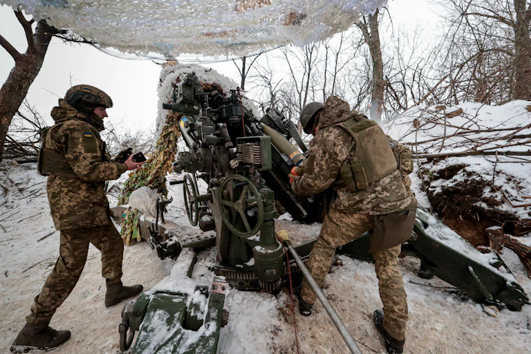Ukrainians load and fire an artillery piece on the frontlines near Zaporizhzhiia