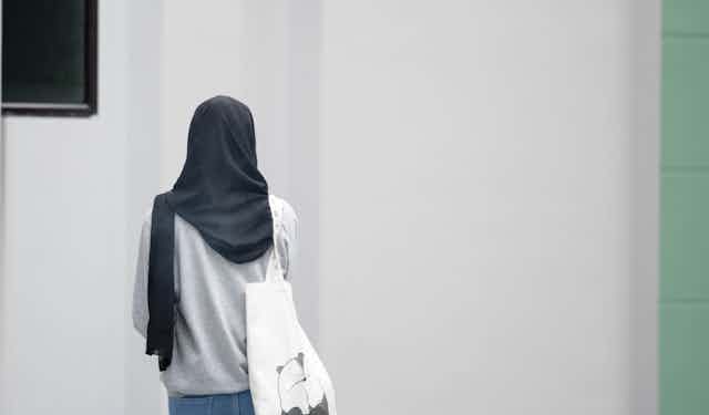 A girl wearing a hijab seen from behind.