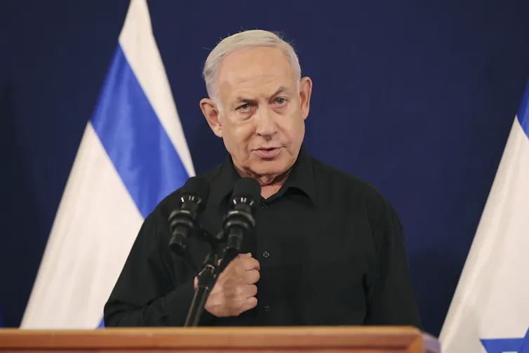 A man in a black shirt behind a lectern gives a speech