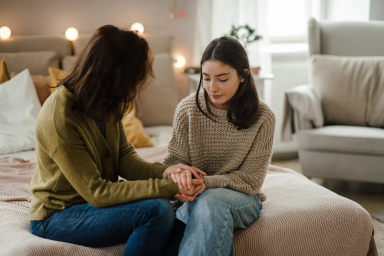 A mother talking to her teenage daughter at home.