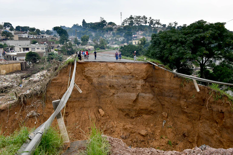 A huge crater in the middle of a road that was washed away by floods