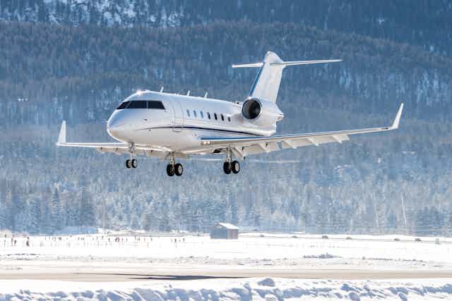 Private jet landing in airport, snowy winter background.