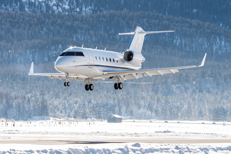 Private jet landing in airport, snowy winter background.