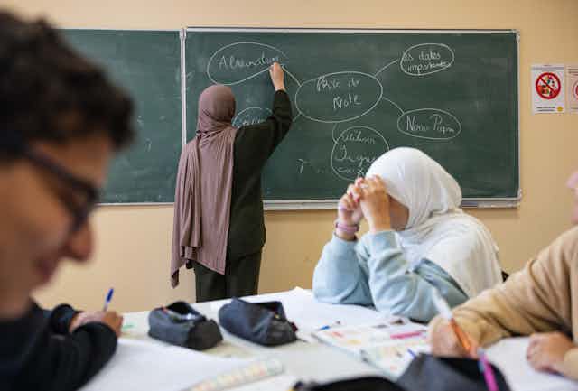 Une élève écrit au tableau pendant un cours au lycée Averroès à Lille, dans le nord de la France, le 28 septembre 2023. 