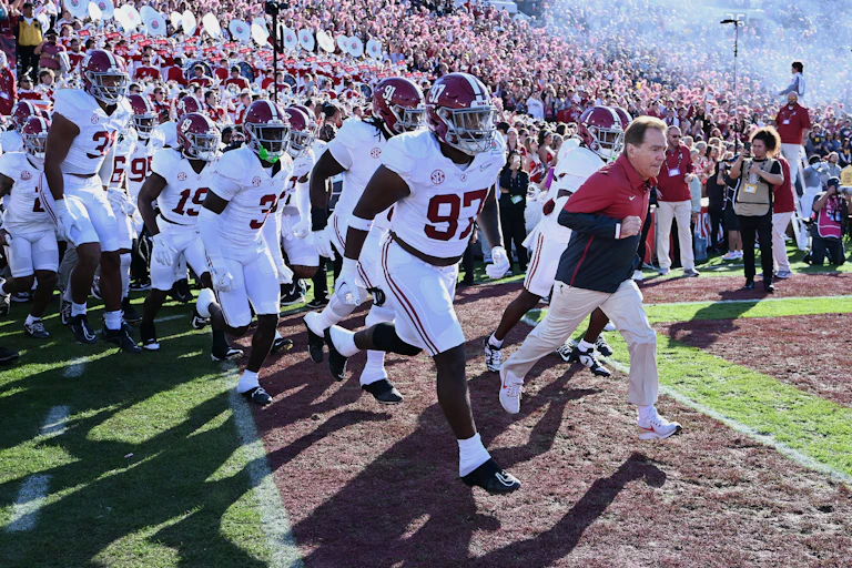 Football coach leads his team running out onto field