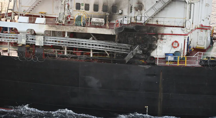 Soot and visible damage on the side of a cargo ship.