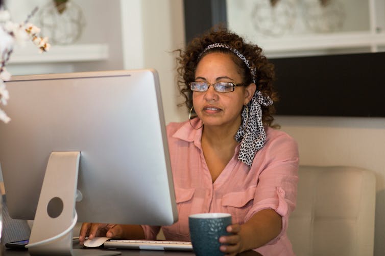 Woman works at desk at home
