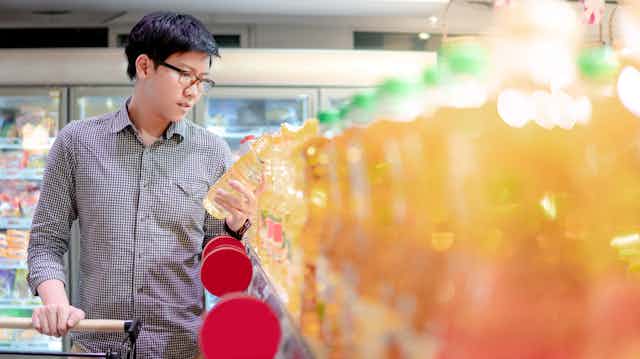 A man analyses cooking oil while in a supermarket.