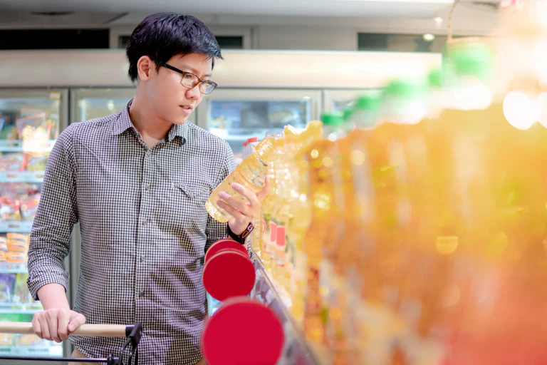A man analyses cooking oil while in a supermarket.