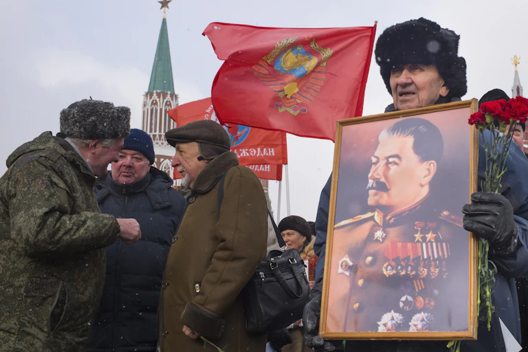 Russian man holds portrait of the late Soviet dictator Josef Stalin.