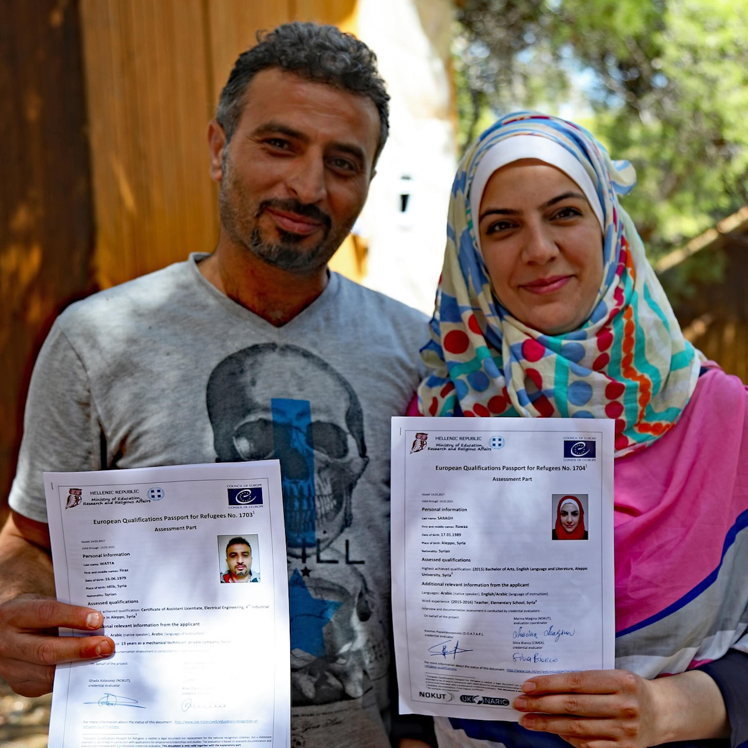 Deux réfugiés montrent leurs passeports européens des qualifications pour les réfugiés.
