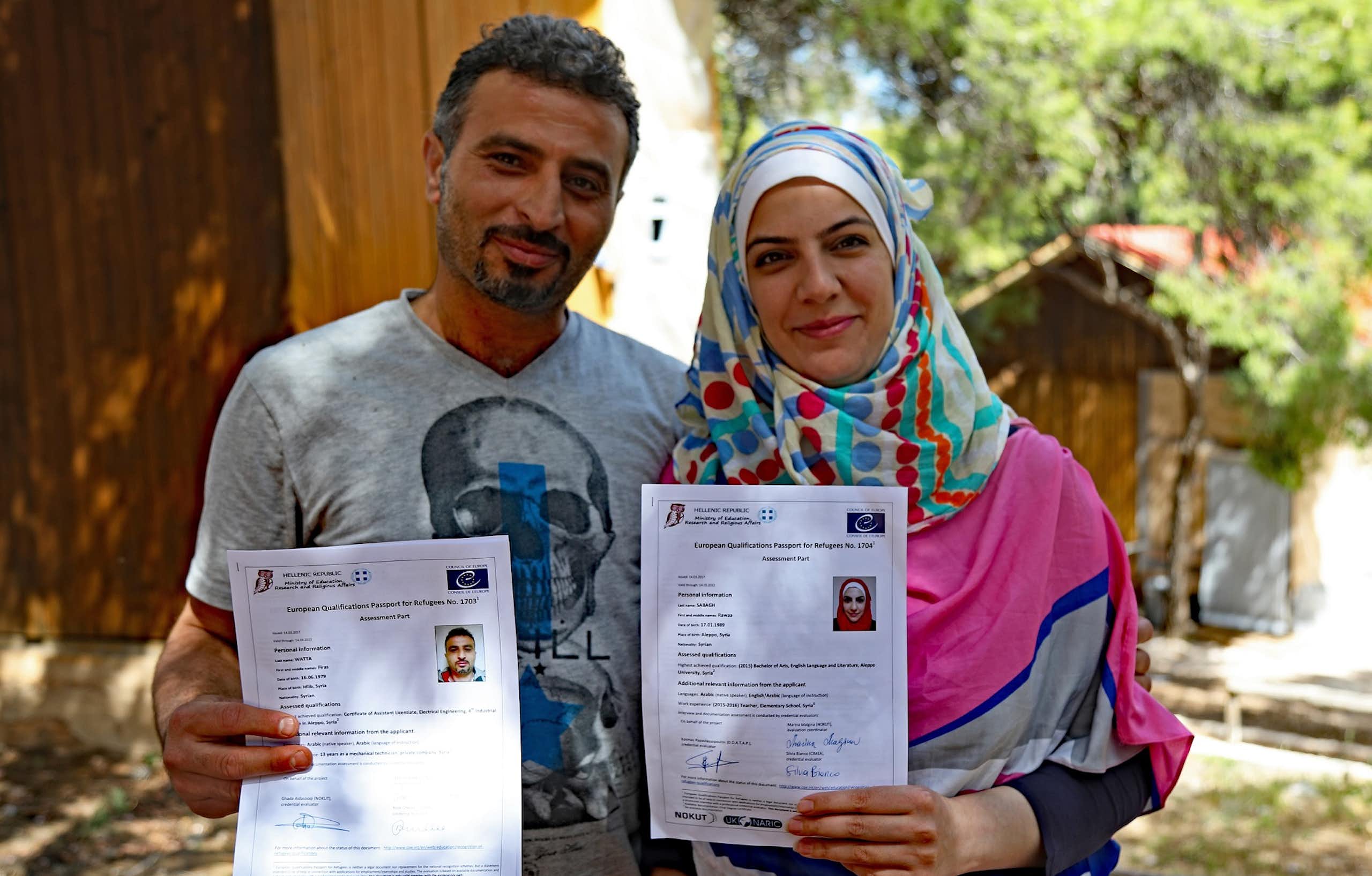 Deux réfugiés montrent leurs passeports européens des qualifications pour les réfugiés.