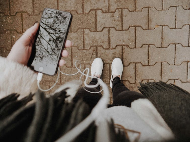 A woman looks down on her phone