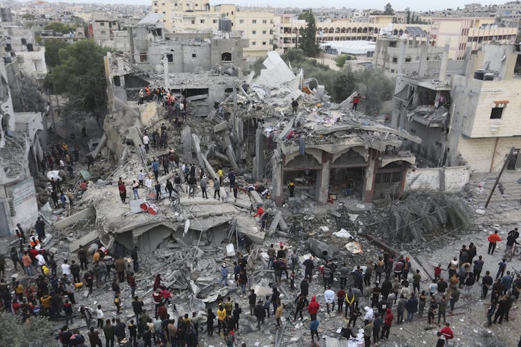 People search a bombed out building for survivors in Rafah, Gaza.