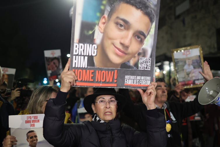 People hold up placards at a demonstration in Israel featuring photos of the Israeli hostages held in Gaza.