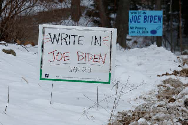 A hand-written sign planted in snow covered ground
