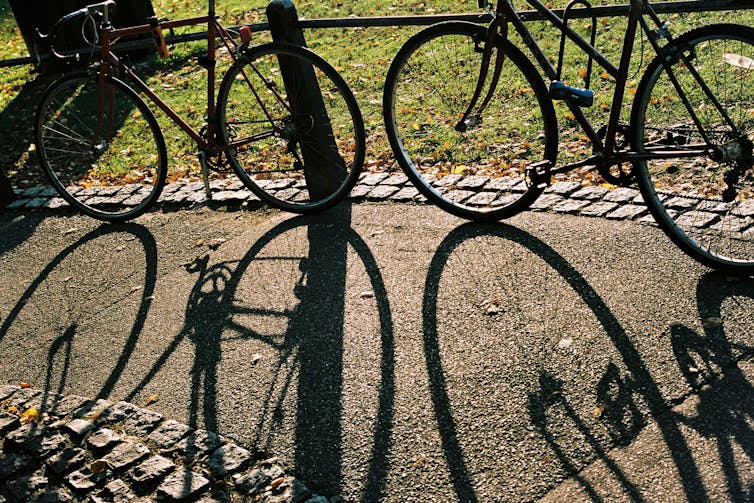 Bikes and bike shadows on a cycle path.