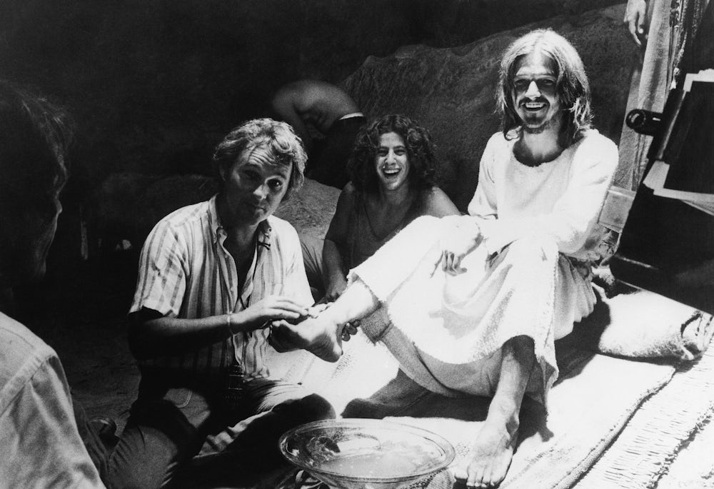 A black and white photograph from the set of the 1973 film “Jesus Christ Superstar.” The director is posing with the actor playing Jesus Christ and another person.