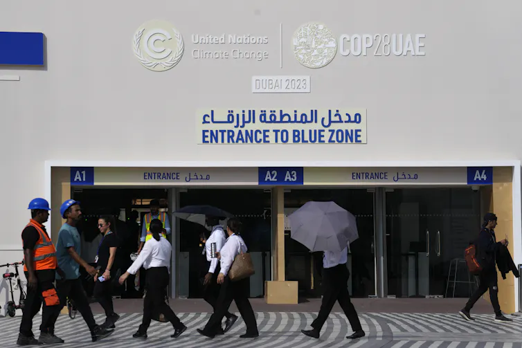 People walk by the entrance to the blue zone.