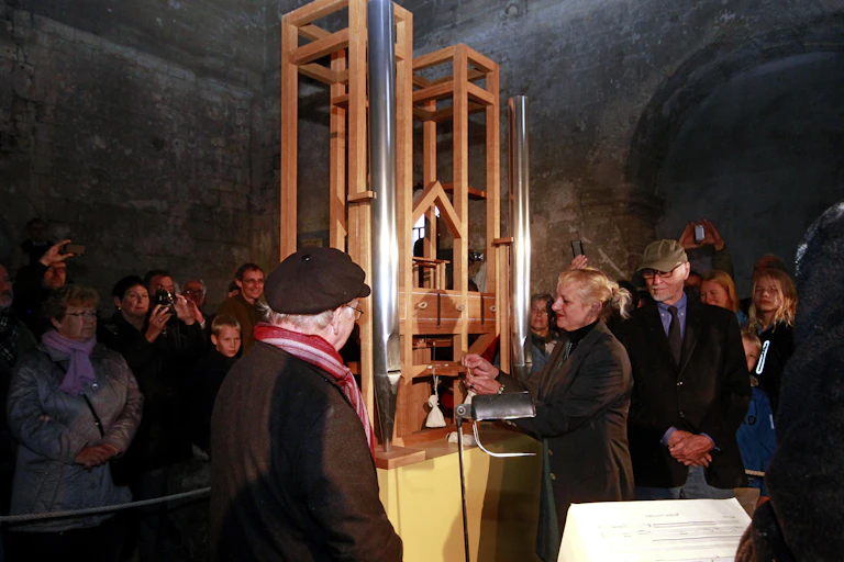 A crowd gathers around an organ.