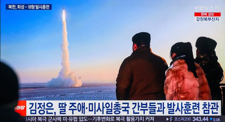 A missile is seen being fired into the air trailed by a plume of smoke.