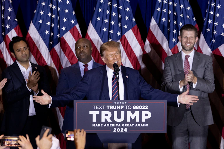 Donald Trump with his arms outstretched delivering a speech.