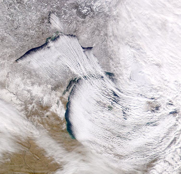 A satellite image shows open water on the western shores the Great Lakes and storms forming to dump snow on the eastern shores.