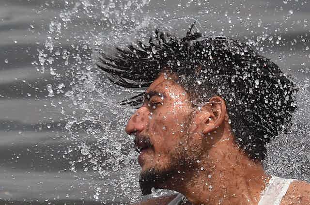 man spraying water from his hair